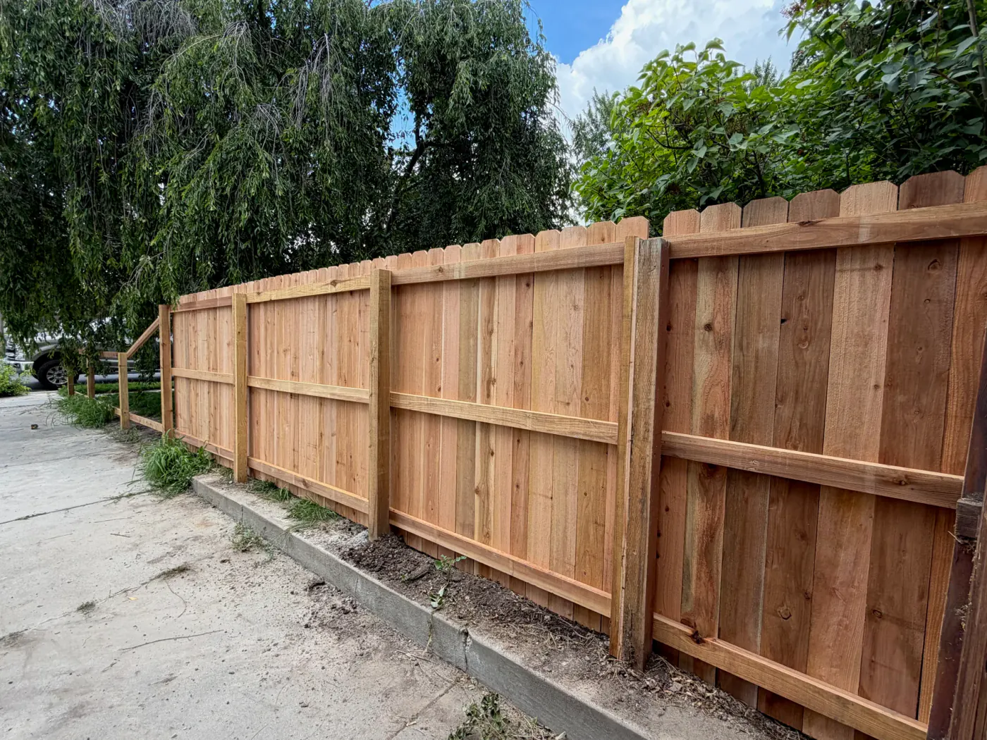 Cedar privacy fence beside a residential driveway, published in Frontier Fence's live project gallery as a Sandy, Utah installation.